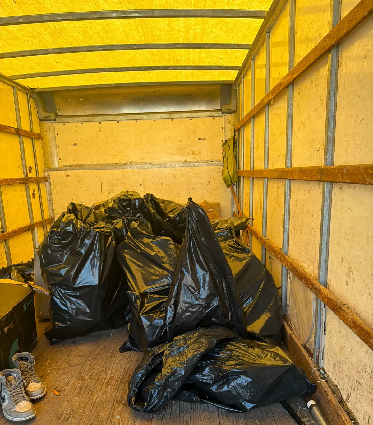 Bagged trash loaded inside a junk removal box truck