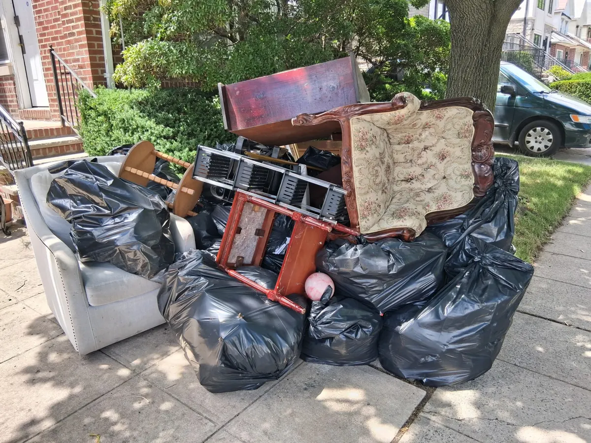 Antique chair, sofa and bagged belongings from an estate cleanout ready for pickup in Brooklyn