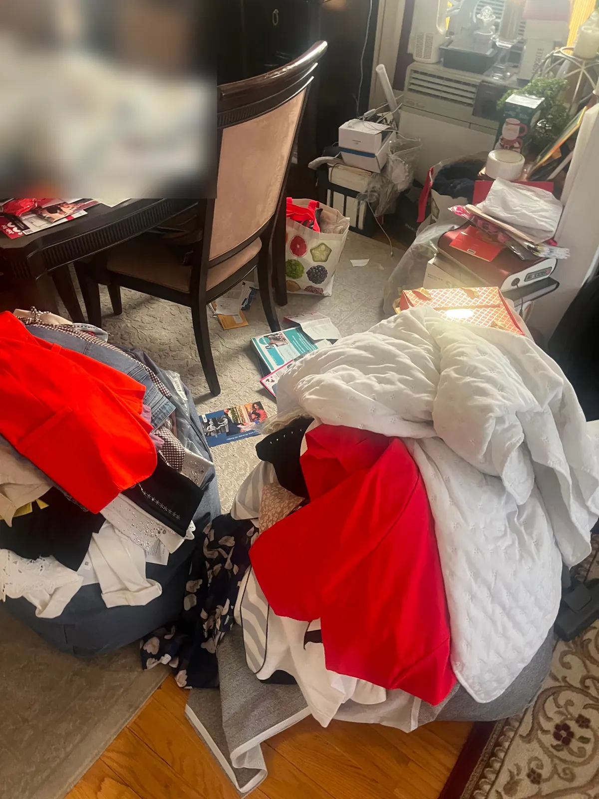 Dining room covered in clothing and papers before a hoarding cleanup