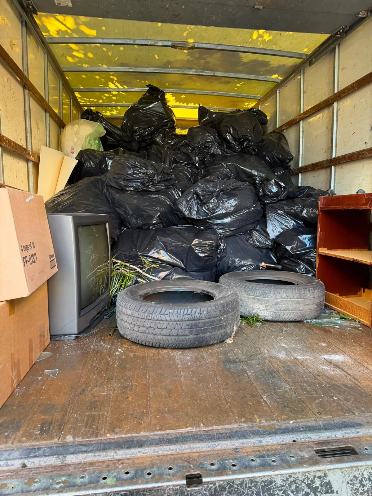 Old tires, a tube TV and bagged junk loaded for recycling and disposal